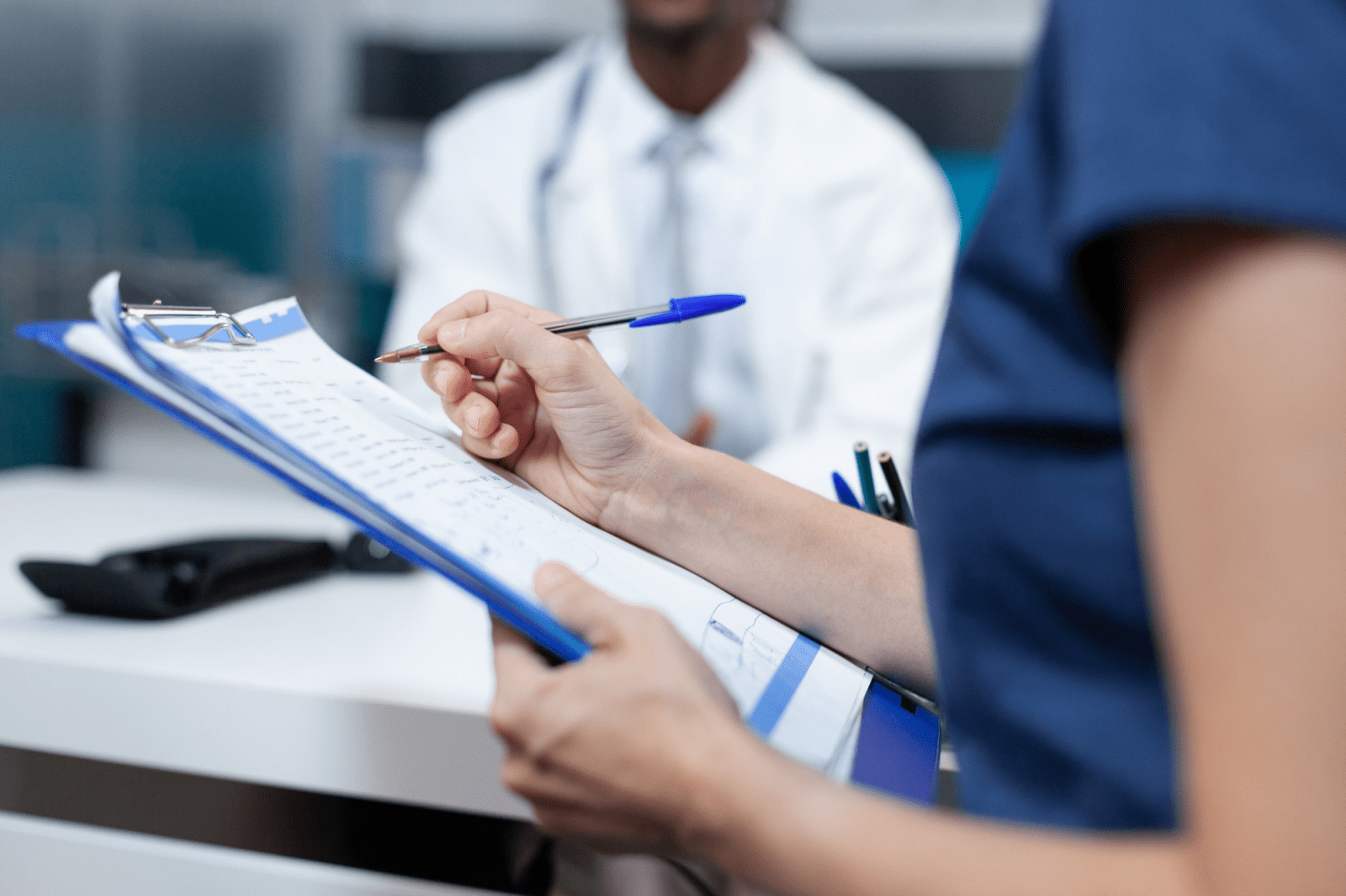 Nurse taking notes on a health record intake sheet