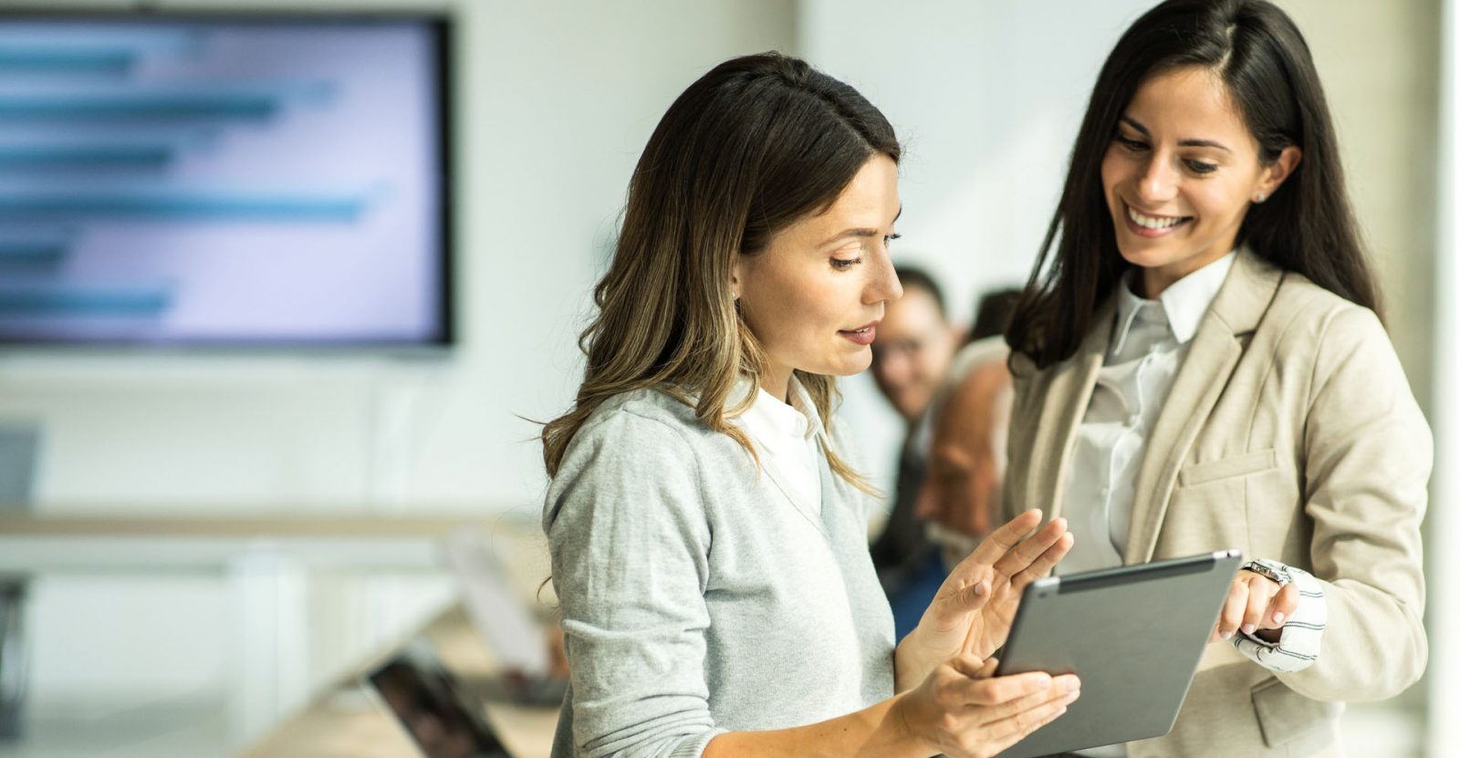 Health System Consulting Services. Female businesswoman holding digital tablet computer discussing Revenue Cycle Optimization