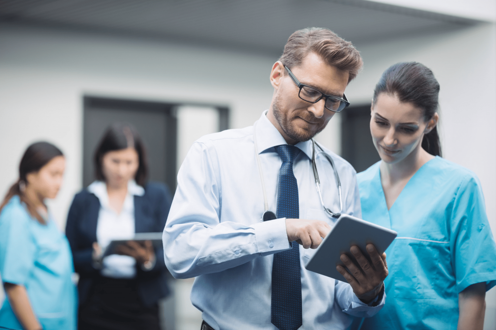 Businessman and hospital staff discussing healthcare data and analytics